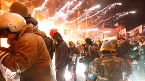 2014年2月18日、キエフの独立広場で、機動隊と衝突する反政府抗議行動参加者達の側で炸裂する花火 ロイター / Yevgeny Volokin