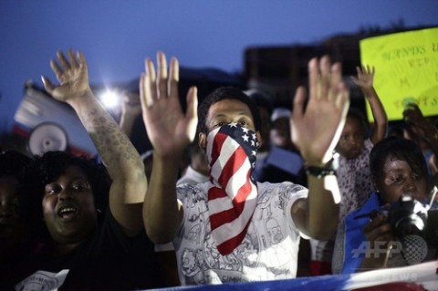 米ミズーリ（Missouri）州ファーガソン（Ferguson）で警官が黒人のマイケル・ブラウン（Michael Brown）さんを射殺したことに抗議する人たち（2014年8月15日撮影）。(c)AFP/Joshua LOTT