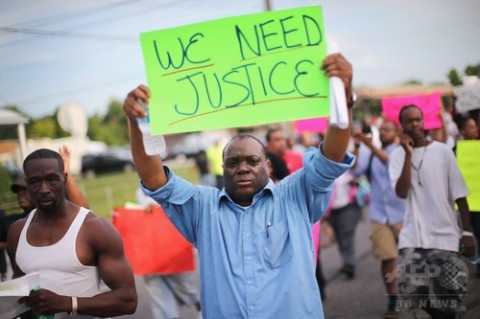 米中西部ミズーリ（Missouri）州ファーガソン（Ferguson）で黒人少年マイケル・ブラウン（Michael Brown）さんが警察官に射殺されたことに抗議するため同地で行われたデモ行進の参加者（2014年8月14日撮影）。(c)AFP/Getty Images/Scott Olson
