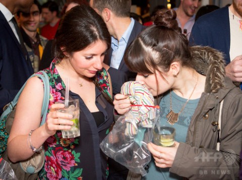 英ロンドン（London）で開催された「フェロモン・パーティー（Pheromone Party）」で、ビニール袋に入ったTシャツのにおいを嗅ぐ参加者（2014年3月25日撮影）。(c)AFP/Stories Bar