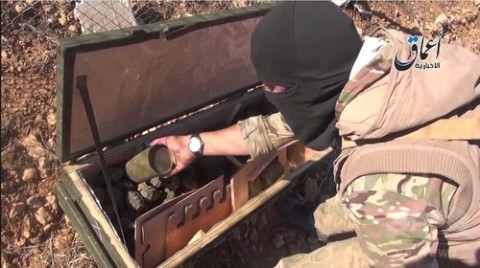 シリア北部の町アインアルアラブ（Ain al-Arab、クルド名：コバニ、Kobane）近郊で武器が入った木箱を開けるイスラム過激派組織「イスラム国（Islamic State、IS）」の戦闘員を撮影したとされる動画のひとこま。イスラム国制圧地域からの映像を投稿するユーチューブ（YouTube）チャンネル「Aamaq News」より（2014年10月21日公開）。(c)AFP/HO/AAMAQ NEWS