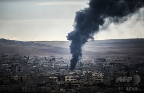 トルコ南東部の村ムルシトピナル（Mursitpinar）から撮影した、シリア北部アインアルアラブ（Ain al-Arab、クルド名：コバニ、Kobane）から立ち上る煙（2014年10月19日撮影）。(c)AFP/BULENT KILIC
